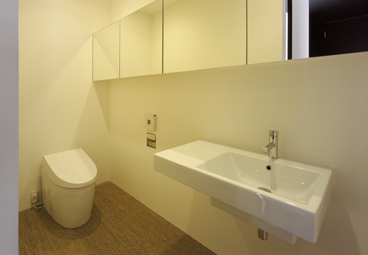 鏡貼りの横長収納が、より広いスペースを演出させるトイレ