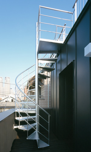ハードな印象がマッチしている、黒のガルバリウム鋼板の外壁とシルバーカラーの外部階段