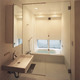 浴室床と洗面床を同じ素材で統一し、清潔感で満たされている広さある浴室洗面所
