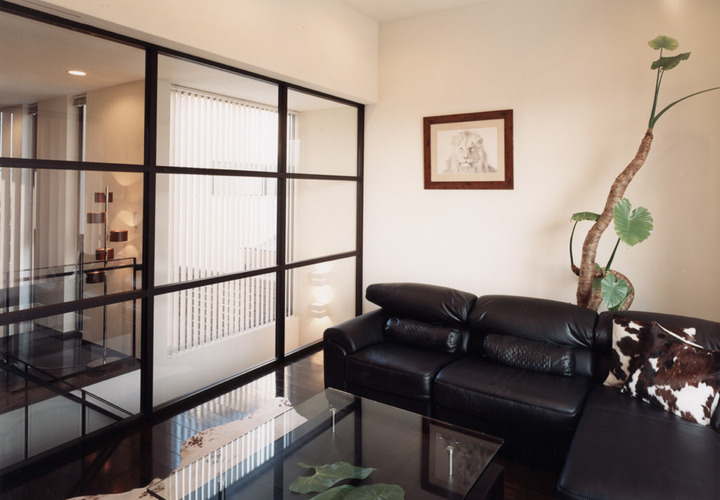 ガラス壁を階段横に設け、明るさと空調の調整のきく空間を得たリビング