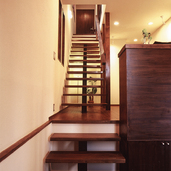 ヌキのある階段から照明の光が抜け軽やかな動きを出す、直線上に並んだ3フロア分の階段