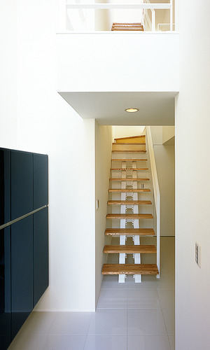 白い壁に、そっと寄り添うように配置されたシンプルな階段