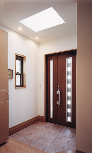 防犯を兼ねて小さくした壁窓とトップライトの光が、玄関を想像以上に明るく照らす