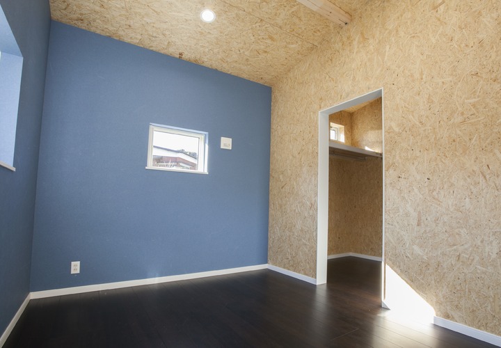 ブルーの壁紙がスタイリッシュな自然素材をふんだんに使用した寝室
