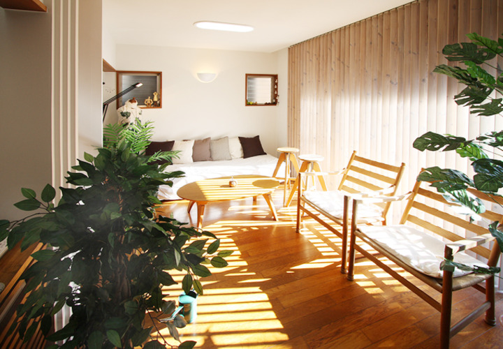 木製縦型ブラインドが陽の光をコントロールする居間