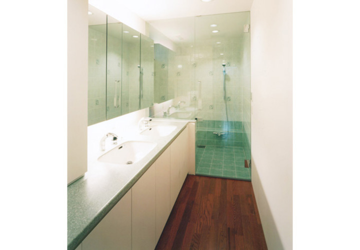 洗面所と連なる透明感のある浴室
