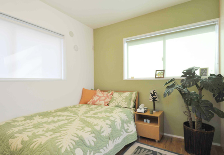 １面をグリーンの壁紙にした落ち着きのある主寝室