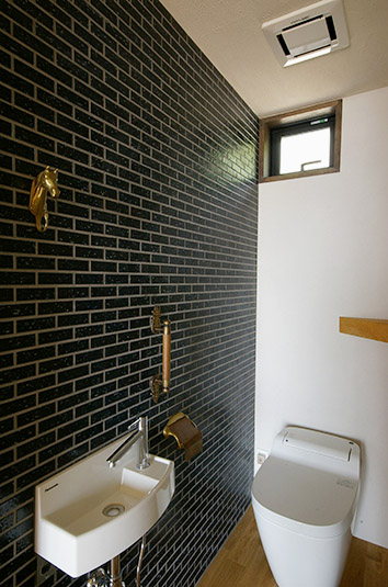 タイルと壁飾りで作るシックな雰囲気のトイレ