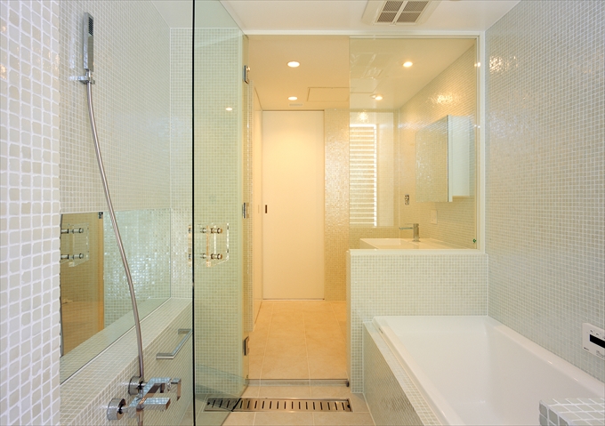 艶めく細かなタイルとガラスで明るい浴室