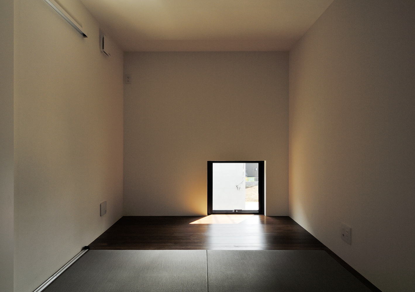 窓の位置を低く抑え部屋を暗めに設定し、モダンな建物の一部に隠れ庵のような和室