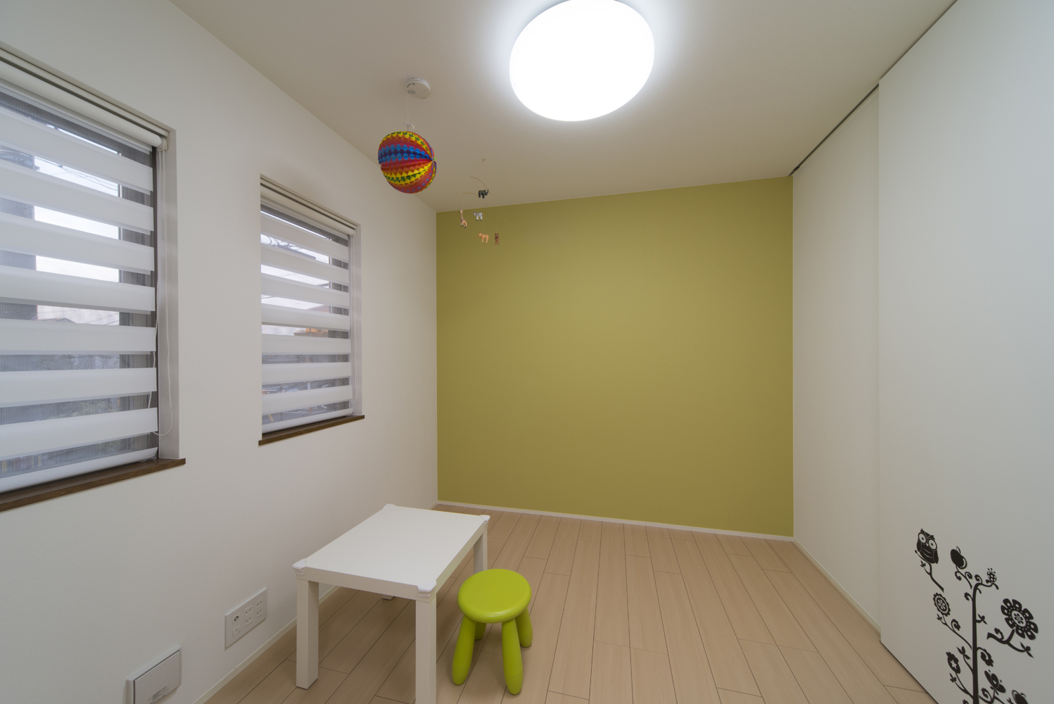 若草色の壁と柔らかい光が入るロールカーテンが印象的な かわいらしい子供部屋 Fevecasa フェブカーサ