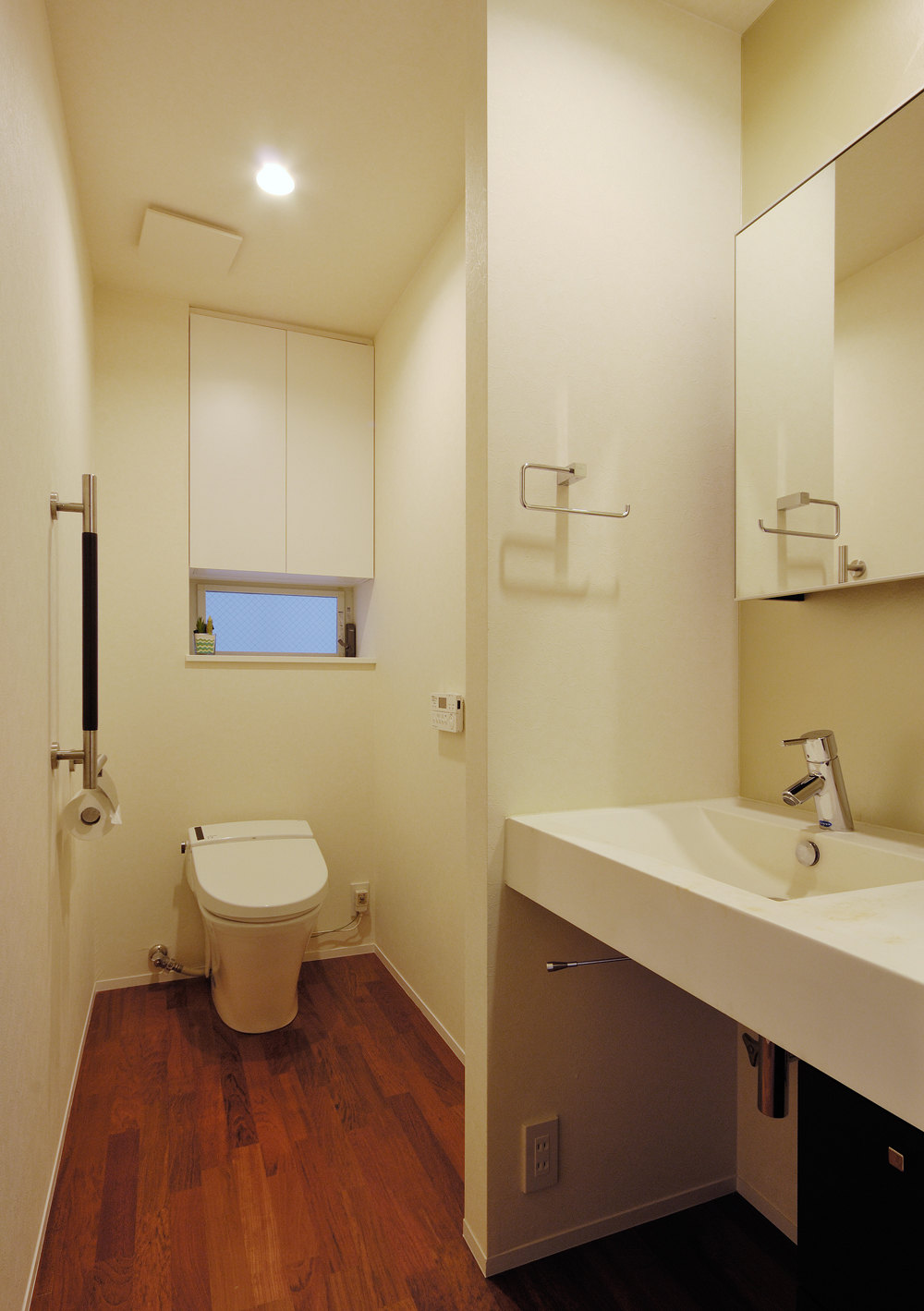 手洗いスペースをゆったりと設けた、ゆとりある縦長空間のトイレ