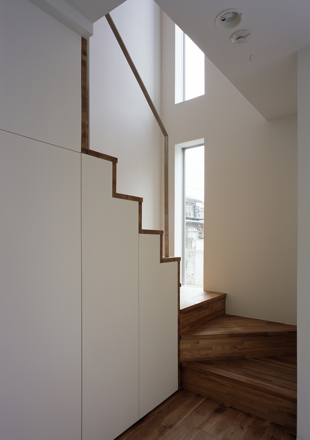 シンプルな佇まいの階段に優しさを与える、2つの縦スリット窓