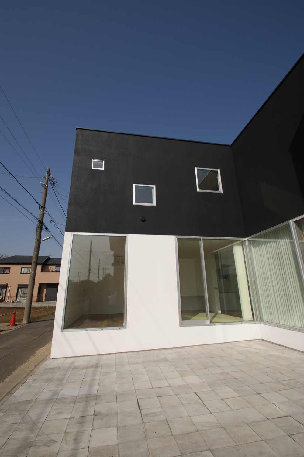 １階２階を二分割させた白黒の外壁、そして窓の大きさに圧倒されるモダンな外観