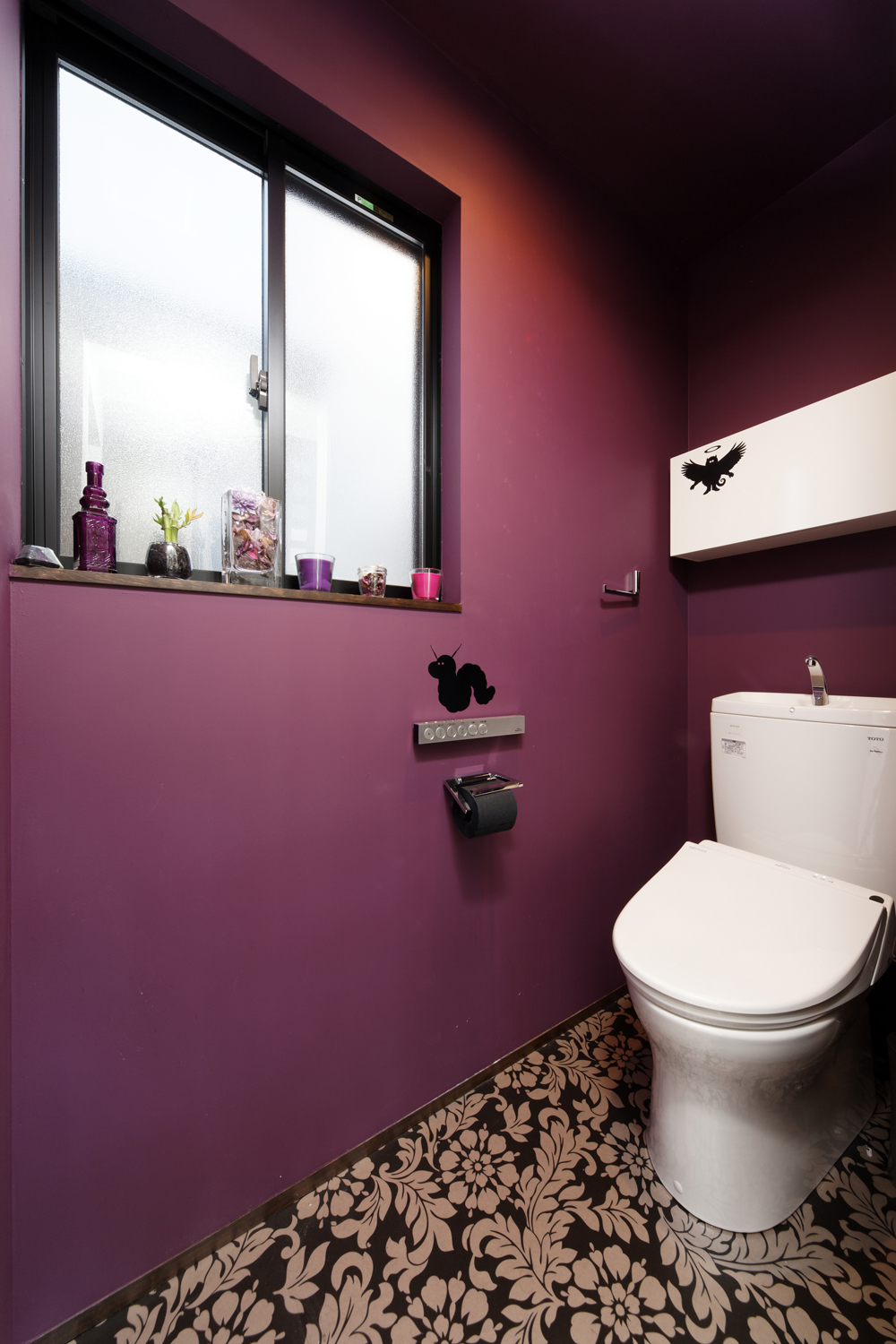 マゼンダカラーの壁と花柄の床が、ノスタルジックなトイレ