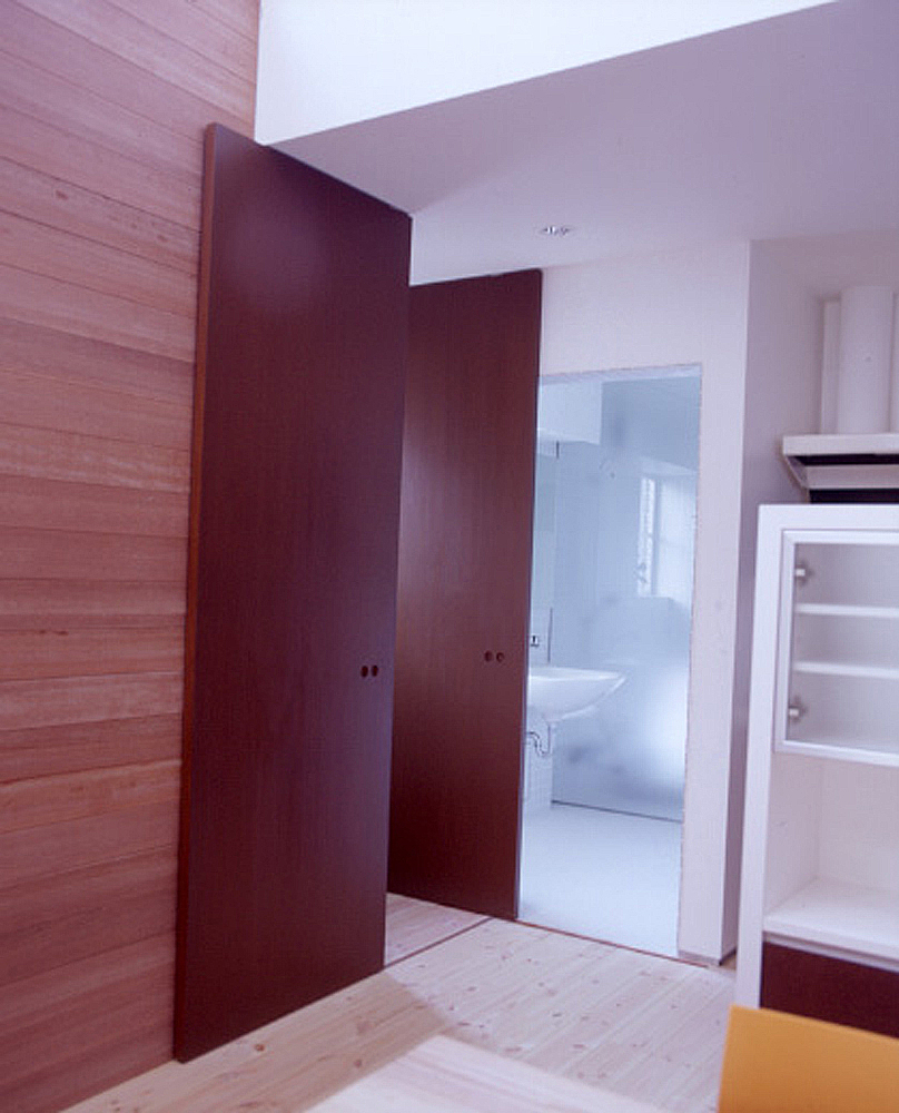 色合いの違う木材を、美しくデザインとして配置した扉・壁・フローリング