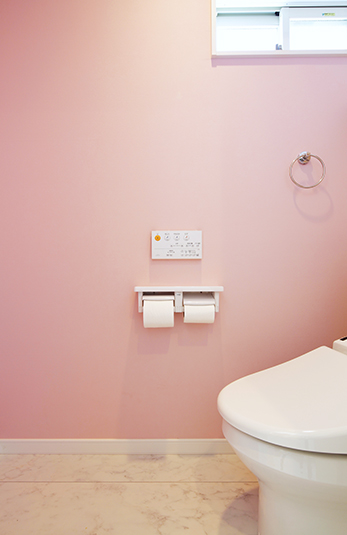 淡いピンクの壁紙が可愛らしいトイレ