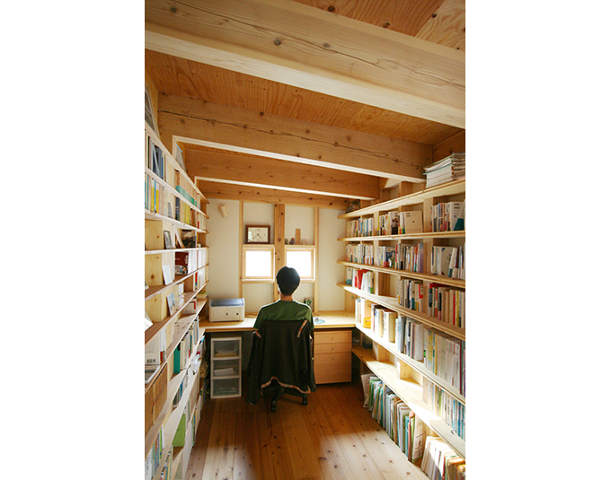 壁面一杯に本棚が作られた杉材現しの書斎