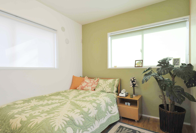 １面をグリーンの壁紙にした落ち着きのある主寝室